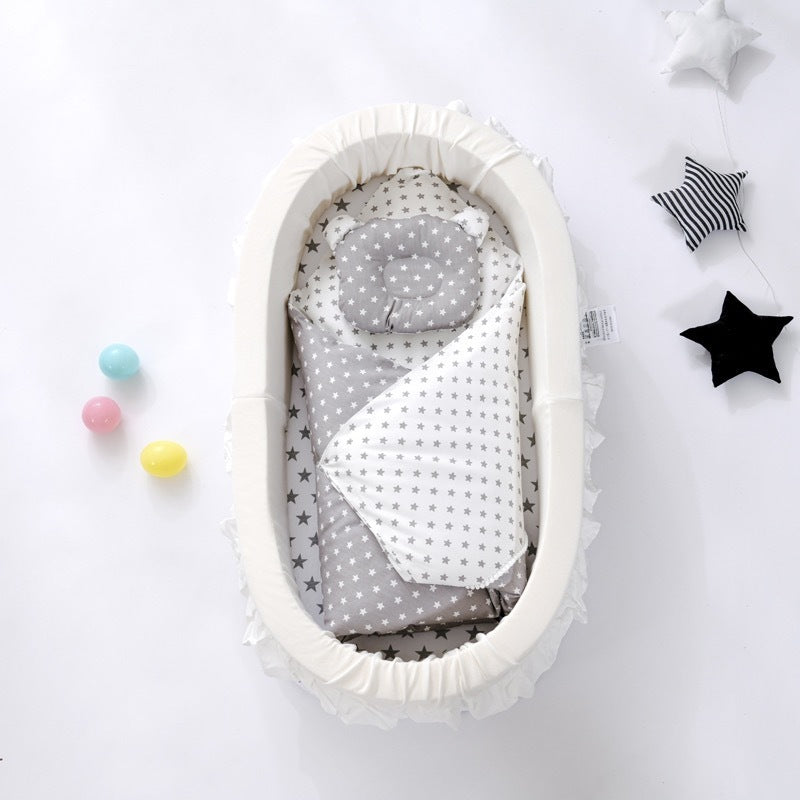 Baby crib with gray and white bedding on a white background